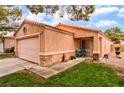 Single-story home with a two-car garage, desert landscaping, and a cozy front porch at 2104 Kendall Hill Ave, Las Vegas, NV 89106