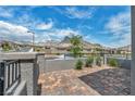Private backyard with brick pavers, low wall, iron fence, landscaping, and mountain view at 2194 Pigeon Hawk St, Las Vegas, NV 89138