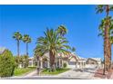 Charming single-story home with palm trees, lush lawn, desert landscaping, and a private driveway leading to a two-car garage at 2201 Country Cottage Ct, Las Vegas, NV 89117