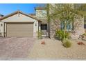 Two-story home with brick driveway, xeriscaping, and a two-car garage at 234 Polaris Ridge Ave, Henderson, NV 89011
