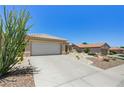 Exterior shot of the property showing the driveway, desert landscaping, and the overall curb appeal at 2545 Banora Point Dr, Las Vegas, NV 89134