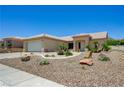 View of the desert landscaped front yard with the tile roof and tan exterior of the house at 2545 Banora Point Dr, Las Vegas, NV 89134