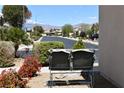 Cozy front yard with desert landscaping, charming bench, and views of mountains in the distance at 3621 Jasmine Heights Ave, North Las Vegas, NV 89081