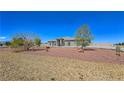 Expansive front exterior showcasing desert landscaping and a circular driveway at 3780 Shawnee Ave, Pahrump, NV 89048
