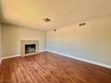 Cozy living room featuring a classic fireplace and wood-look flooring at 4766 Knollwood Dr, Las Vegas, NV 89147