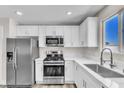 Modern kitchen with stainless steel appliances, white cabinets, and countertop space at 4813 Plata Del Sol, Las Vegas, NV 89121