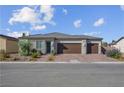 Inviting single-story home with a three-car garage, rock landscaping and appealing front entrance at 5357 Eleganza Ave, Pahrump, NV 89061