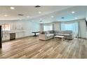 Spacious living room with open concept, wood floors, and a view of the modern kitchen at 6191 Bullion Blvd, Las Vegas, NV 89103