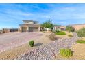 Two-story stucco home with desert landscaping, two-car garage and brick driveway at 6311 Baker Creek St, Las Vegas, NV 89149