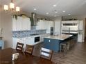 Spacious kitchen featuring white cabinetry, modern appliances, a large center island, and stylish backsplash at 6311 Baker Creek St, Las Vegas, NV 89149