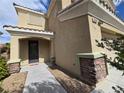 Welcoming front entrance featuring a stylish front door and decorative stone accents and well-maintained walkway at 6638 Babys Tear Pl, Las Vegas, NV 89148