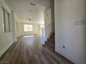 Bright living room featuring hardwood floors, large windows, and access to the staircase at 6638 Babys Tear Pl, Las Vegas, NV 89148