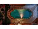 Aerial view of an outdoor backyard pool and spa with string lights and patio at 7300 Fresh Harvest Ave, Las Vegas, NV 89131