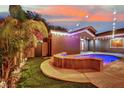 Outdoor pool and spa with a waterfall feature and lush tropical backyard landscaping at 7300 Fresh Harvest Ave, Las Vegas, NV 89131