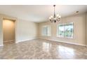 Inviting living room featuring tile flooring, neutral walls, a chandelier and large windows with bright natural light at 7332 Redhead Dr, North Las Vegas, NV 89084