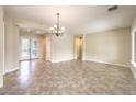 Bright living room featuring tile flooring, neutral walls, decorative chandelier, and an entryway with glass doors at 7332 Redhead Dr, North Las Vegas, NV 89084