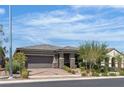 Beautiful single-story house with manicured landscaping, brick driveway, and a two-car garage at 789 Drammatico Pl, Henderson, NV 89011