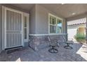 Cozy front porch with two chairs and decorative stone accents adds charm to this home at 789 Drammatico Pl, Henderson, NV 89011