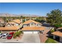 Two-story home with a three-car garage, manicured landscaping, and terracotta roof tiles at 8436 Kawala Dr, Las Vegas, NV 89128