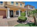 Charming front entrance with elegant columns, well-manicured landscaping, and a brick walkway leading to the front door at 8448 Cambria Cellars Ct, Las Vegas, NV 89139