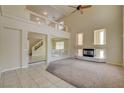 Bright living room with fireplace, carpeted floors, and large windows, creating a warm and inviting atmosphere at 8448 Cambria Cellars Ct, Las Vegas, NV 89139