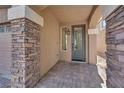 Inviting front entrance with stone pillars and a decorative glass door set on a paved brick surface at 9604 Stoney Mesa Ct, Las Vegas, NV 89139