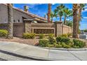 Entrance to Aurora Canyon with stone sign and brick wall surrounded by well manicured plants and trees at 9621 Donner Springs Ave, Las Vegas, NV 89148