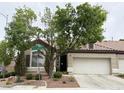 Charming single-story home featuring a well-maintained front yard, two-car garage, and mature shade trees at 9621 Donner Springs Ave, Las Vegas, NV 89148