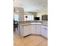 Eat-in kitchen shows granite countertops, white cabinets, stainless appliances, and tile flooring at 9621 Donner Springs Ave, Las Vegas, NV 89148