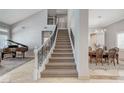Spacious foyer showcasing the staircase, piano, and adjacent dining area at 10249 Wisteria Hills Ct, Las Vegas, NV 89135