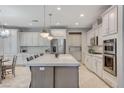 Modern kitchen with stainless steel appliances, white cabinetry, and a large island with seating at 10249 Wisteria Hills Ct, Las Vegas, NV 89135