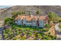 Elegant multi-story home with a tile roof, multiple balconies, and mature landscaping on a hillside at 12 Strada Di Circolo, Henderson, NV 89011
