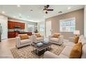 Bright living room with tile flooring, plush seating, and an open layout to the kitchen at 208 Coltrane Canyon Ave, Henderson, NV 89011