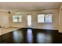 Spacious living room with dark wood floors and a sliding glass door for backyard access at 224 Wicked Wedge Way, Las Vegas, NV 89148
