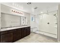 Modern bathroom with dual sinks, granite countertops, and a large walk-in shower with glass enclosure at 2333 Mundare Dr, Henderson, NV 89002