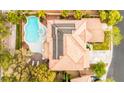 Aerial view of a landscaped backyard featuring a sparkling pool, spa, patio, and well-maintained red-tiled roof at 366 Rancho La Costa St, Las Vegas, NV 89138