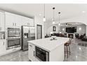 Bright kitchen features a large island with a marble countertop, stainless steel appliances, and seamless access to the living room at 366 Rancho La Costa St, Las Vegas, NV 89138