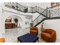 Open concept living room and staircase with iron railings and arched entries and neutral colors at 366 Rancho La Costa St, Las Vegas, NV 89138