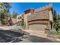 Unique home with stone accents and a large garage, surrounded by mature trees at 4162 Matterhorn Way, Las Vegas, NV 89124