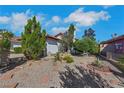 This yard is gravel-filled with desert trees and plants surrounding the home's exterior walls at 4629 Denwood Dr, Las Vegas, NV 89147