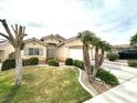 Inviting single-story home with lush front yard and mature palm trees at 4713 Vista Del Rey Ct, North Las Vegas, NV 89031