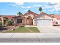 Attractive single-story home featuring a red tile roof, desert landscaping, and a two-car garage at 517 Casa Del Norte Dr, North Las Vegas, NV 89031