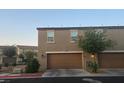 A townhouse with an attached two-car garage with a well-maintained driveway and green landscape at 5209 Silica Chalk Ave, Las Vegas, NV 89115