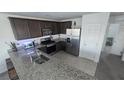 Well-lit kitchen with granite countertops, stainless steel appliances, and dark wood cabinets at 5209 Silica Chalk Ave, Las Vegas, NV 89115