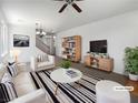 Stylishly staged living room featuring modern furniture, neutral tones, a ceiling fan, and ample natural light at 8253 Pearl Oasis Ct, Las Vegas, NV 89139