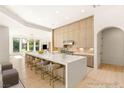 Modern kitchen boasts a large island with seating, sleek cabinets, and an open layout for seamless living and entertaining at 8895 S Tenaya Way, Las Vegas, NV 89113