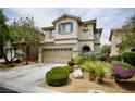 Inviting two-story home boasts a landscaped front yard, attached garage, and charming architectural details at 9144 Clear Sky Ave, Las Vegas, NV 89178
