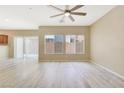 Spacious living room with wood-look flooring, ceiling fan, and sliding glass door at 928 Shades End Ave, North Las Vegas, NV 89081