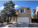 Two-story home featuring a desert landscaped front yard, a large tree, and a two-car garage at 1030 Country Skies Ave, Las Vegas, NV 89123