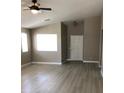 A bright living room with a ceiling fan and modern laminate flooring and a large window at 10342 Spider Rock Ave, Las Vegas, NV 89135